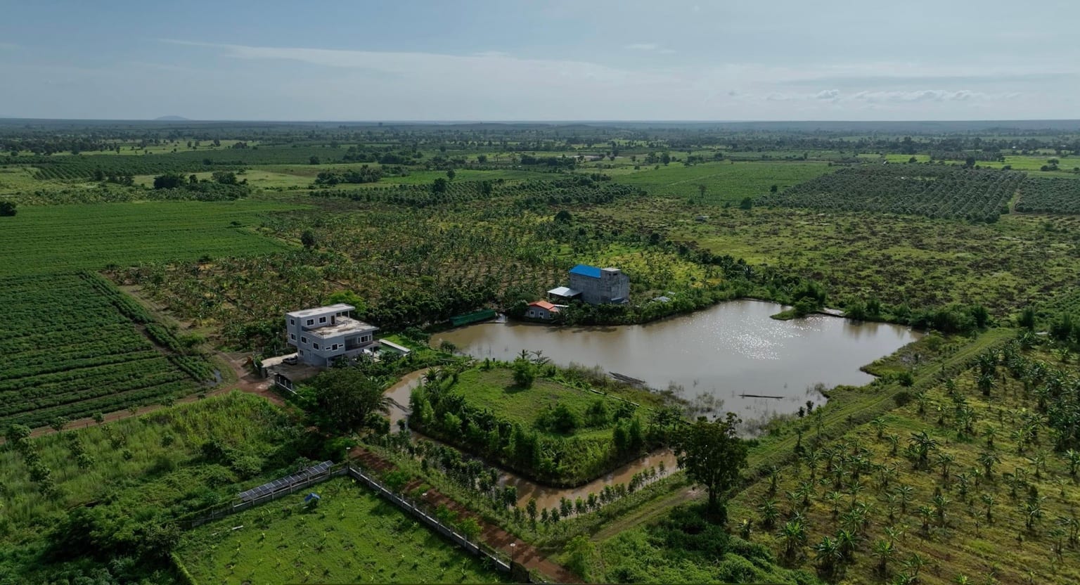 Aerial view of Eden Farm's agricultural land, house, and pond in Kampong Cham